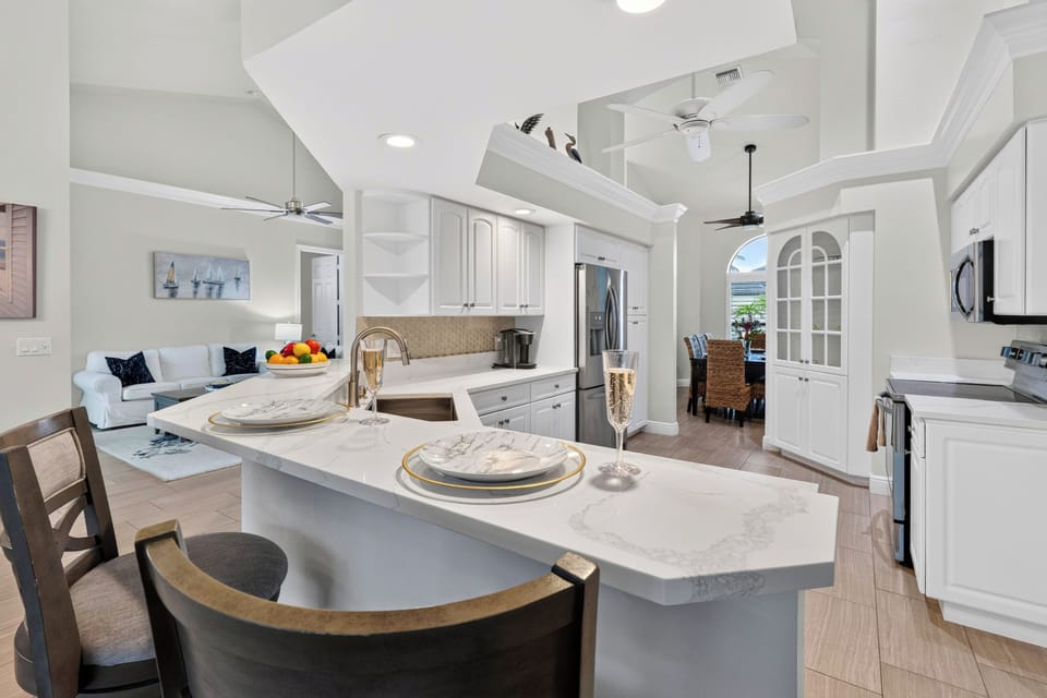 Expansive kitchen view showcasing the grand layout, wraparound counters, and close proximity to dining areas.