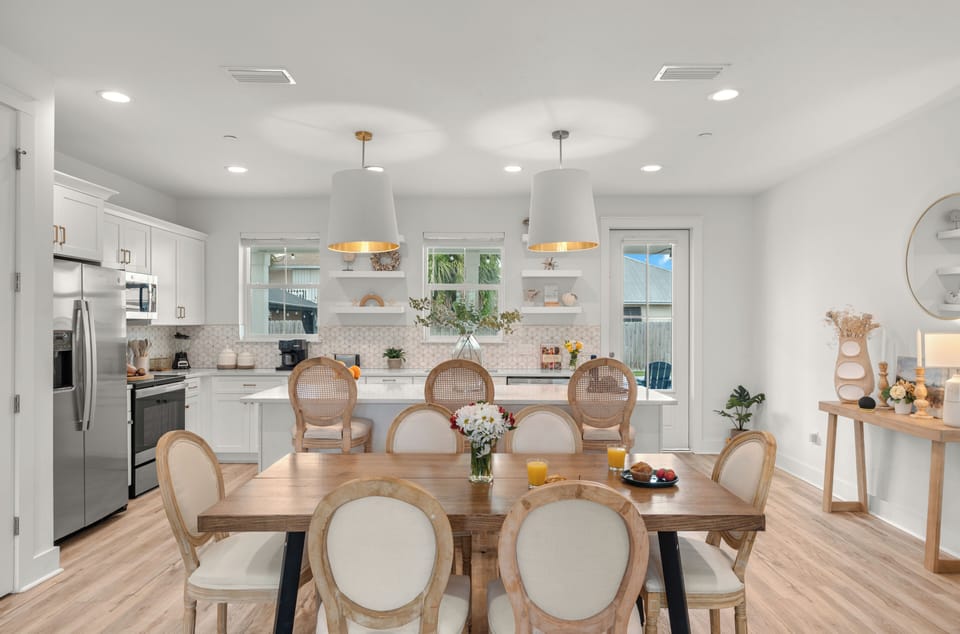 Bright dining and kitchen area with coastal style, island seating, and easy backyard access. (Unit A)