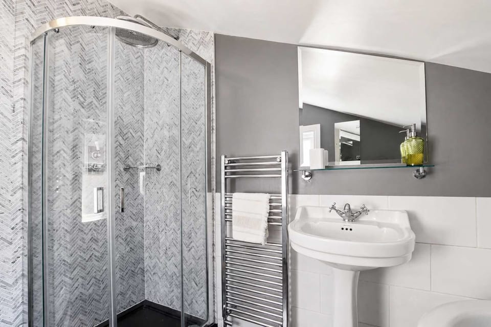 Bathroom: Sleek shower, heated towel rail, and crisp modern finishes for your morning refresh!