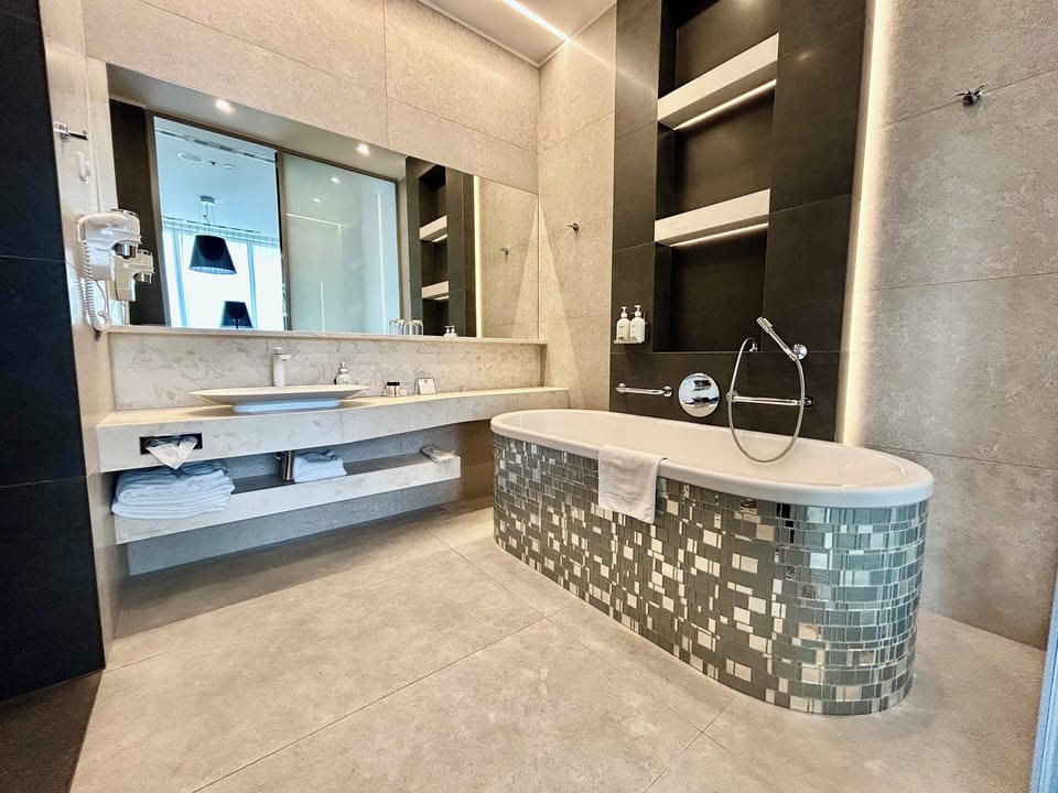 Suite, 1 King Bed, Balcony, City View | Bathroom | Separate tub and shower, deep soaking tub, free toiletries, hair dryer