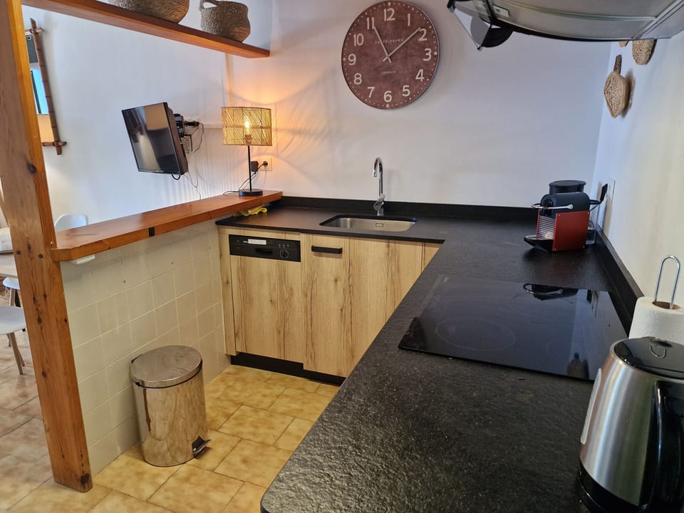 Practical everyday details: A modern capsule coffee machine and an efficient dishwasher in a stylishly designed kitchen.