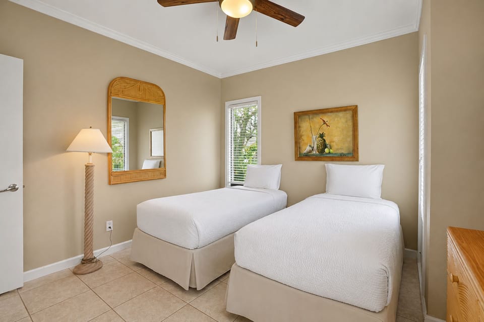 Settle into your private twin-bedded retreat with crisp white linens, gentle natural light, and coastal-inspired décor creating a serene escape for restful nights.