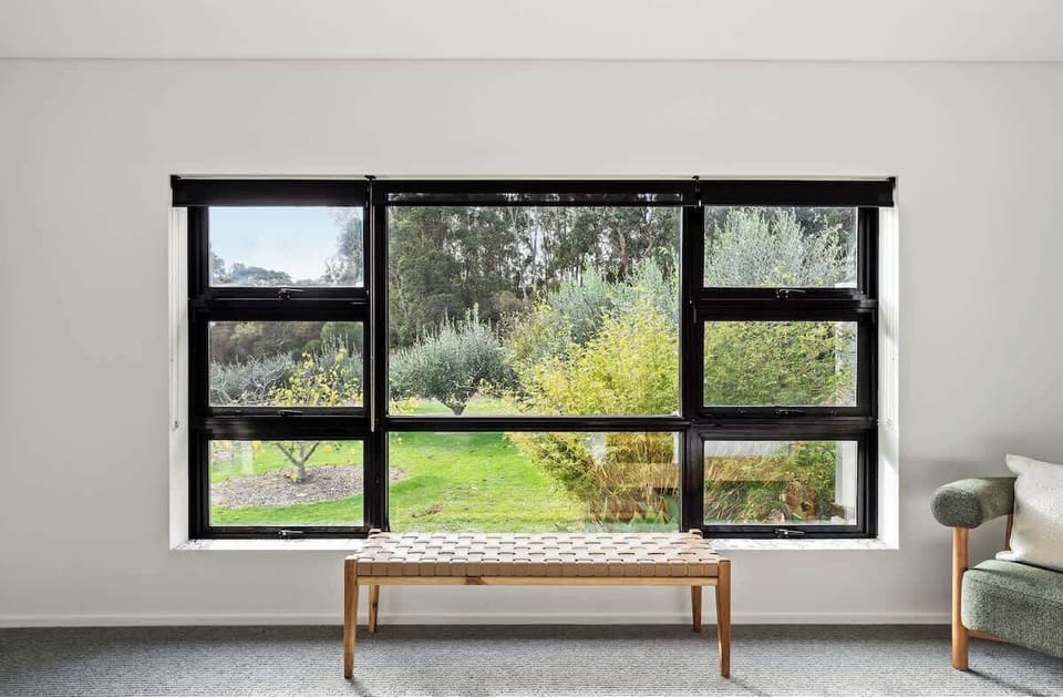 Pause by the window seat in the primary bedroom and take in views across the orchard and surrounding greenery as natural light fills the space.