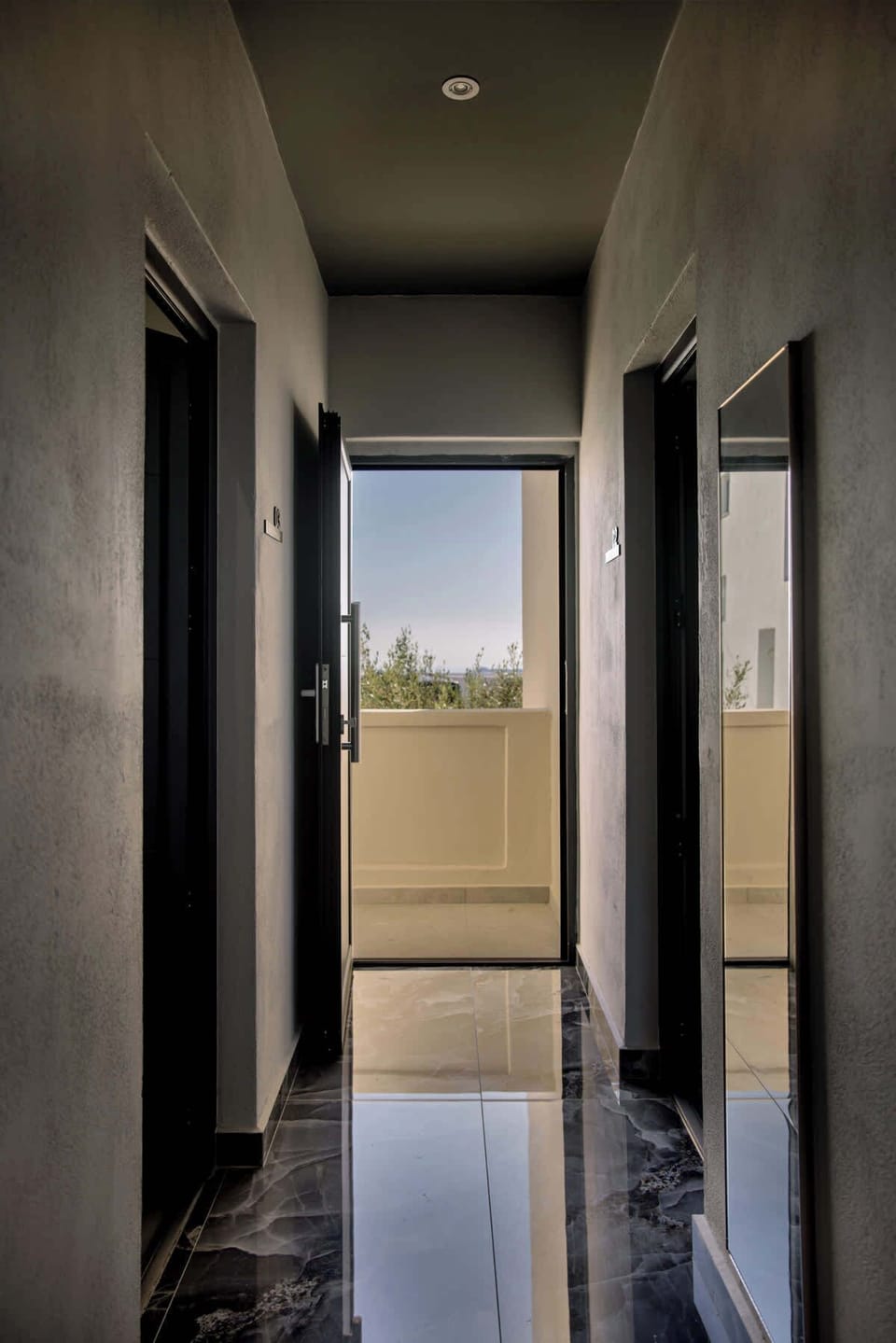 Bright hallway leading into the studio with a glimpse of the sea beyond.