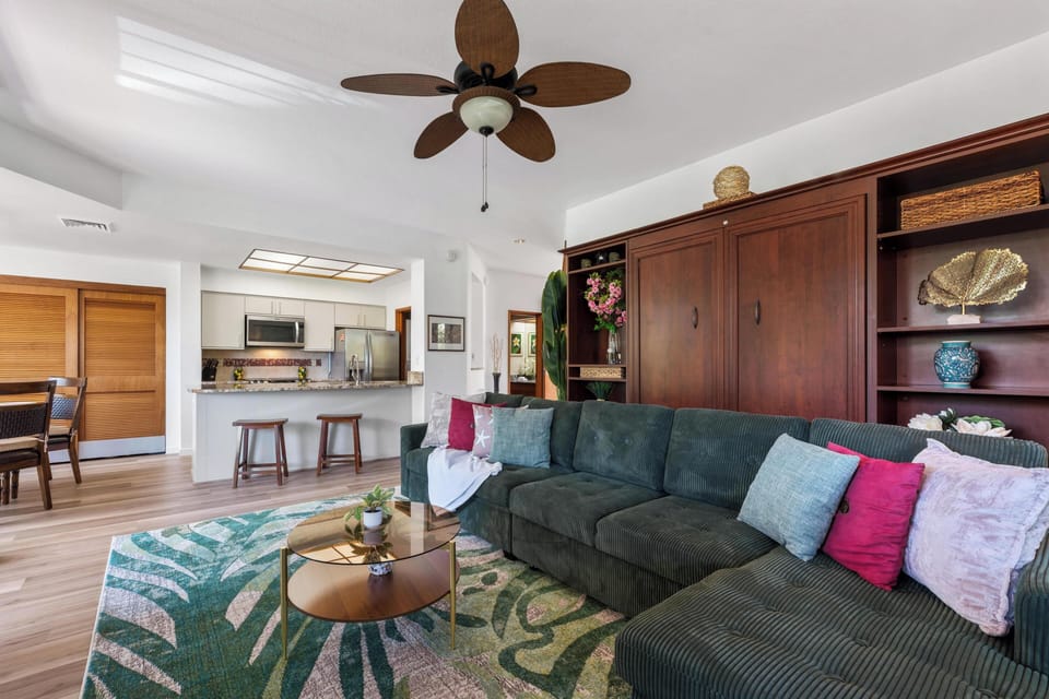 Sink into your oversized teal sofa beneath tropical ceiling fans, with a fully equipped kitchen steps away. Open-plan design and natural light create your perfect home base.