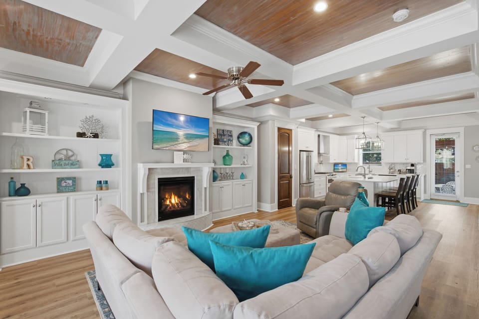 Relax in your spacious open-concept living space with a cozy fireplace, modern kitchen, and coastal-inspired décor that invites you to unwind after a day of adventure.