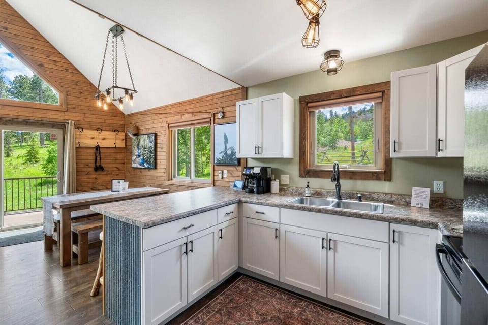 This inviting view highlights the fully equipped kitchen, spacious island, and dining area—perfect for cooking, gathering, and sharing meals together.