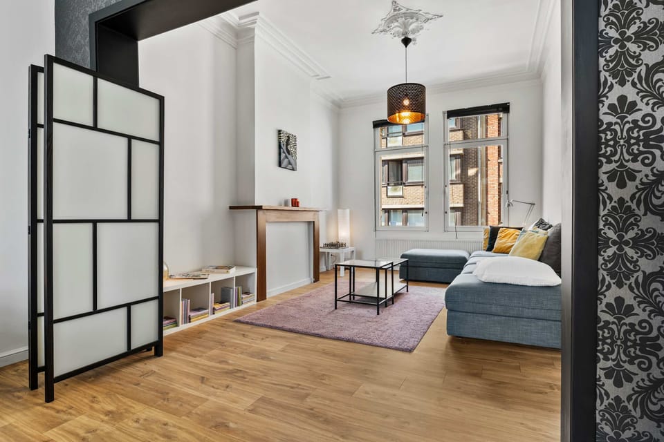 Cosy lounge with comfortable sofa and stylish room divider – relaxing living space in the Grand Ostend townhouse with private sauna, near Oostende beach