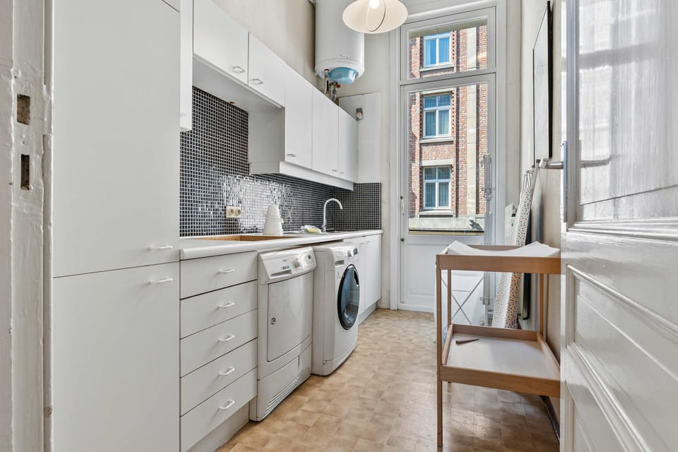 Fully equipped wash room with white cabinetry, washing machine – Grand Ostend townhouse with private sauna, near Oostende beach