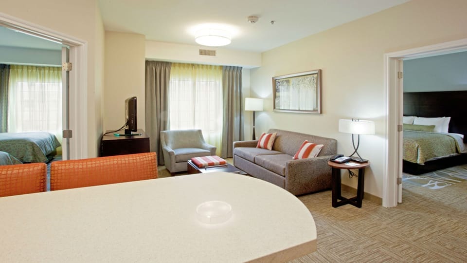 Open living area with sofa, armchair, and kitchenette area.