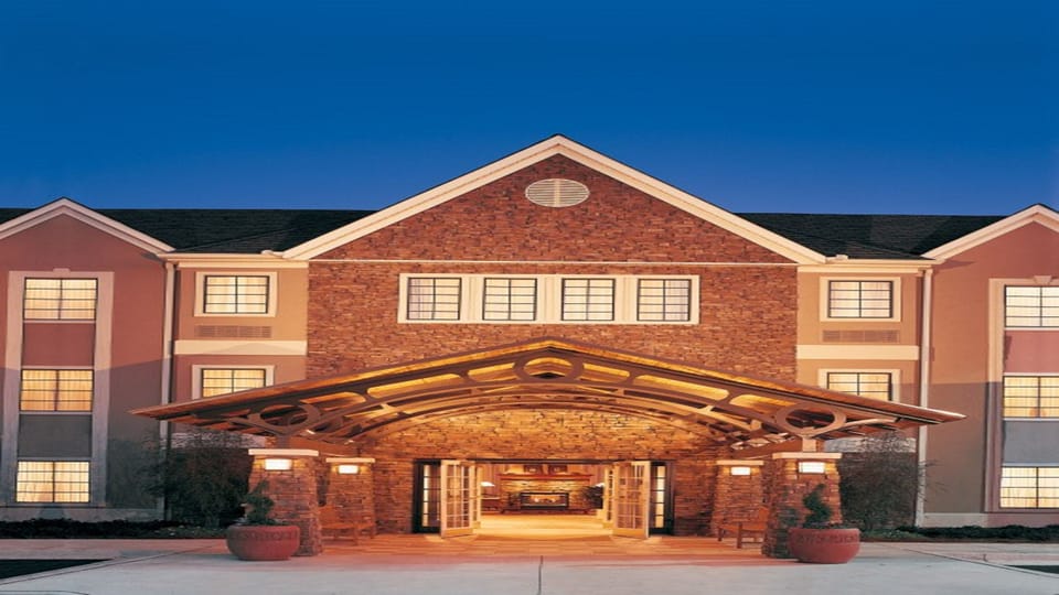 Welcoming hotel exterior with architectural stone and brick facade at dusk.