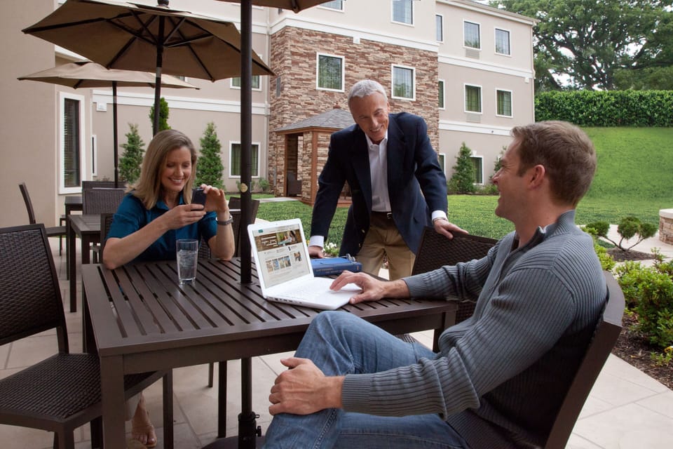Outdoor patio lounge with comfortable seating amid lush landscaping.