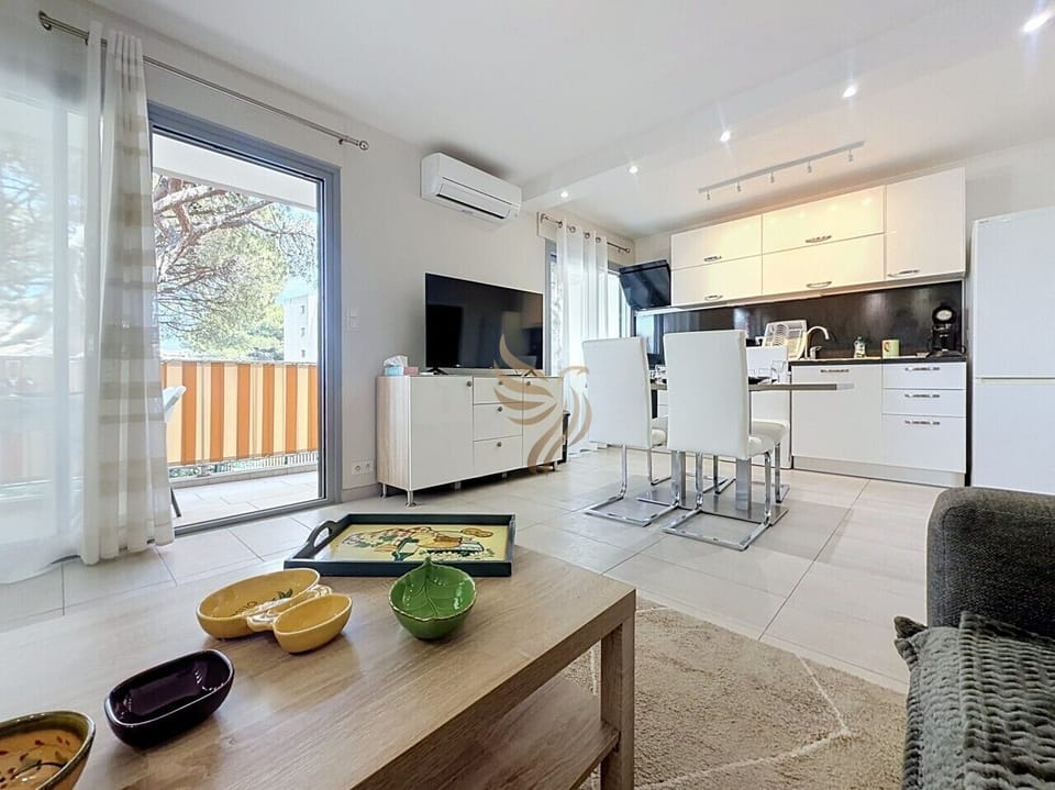 Installez-vous près de la porte-fenêtre, savourez un café fraîchement préparé dans la machine et regardez la lumière filtrer à travers le balcon, un salon-cuisine moderne pensé pour la détente et les repas conviviaux.