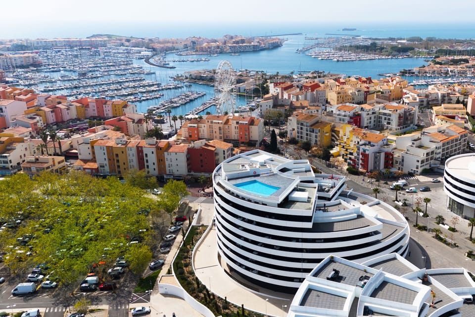 Cap d'Agde's marina from above — boats, a Ferris wheel, and the Languedoc coastline right on your doorstep.