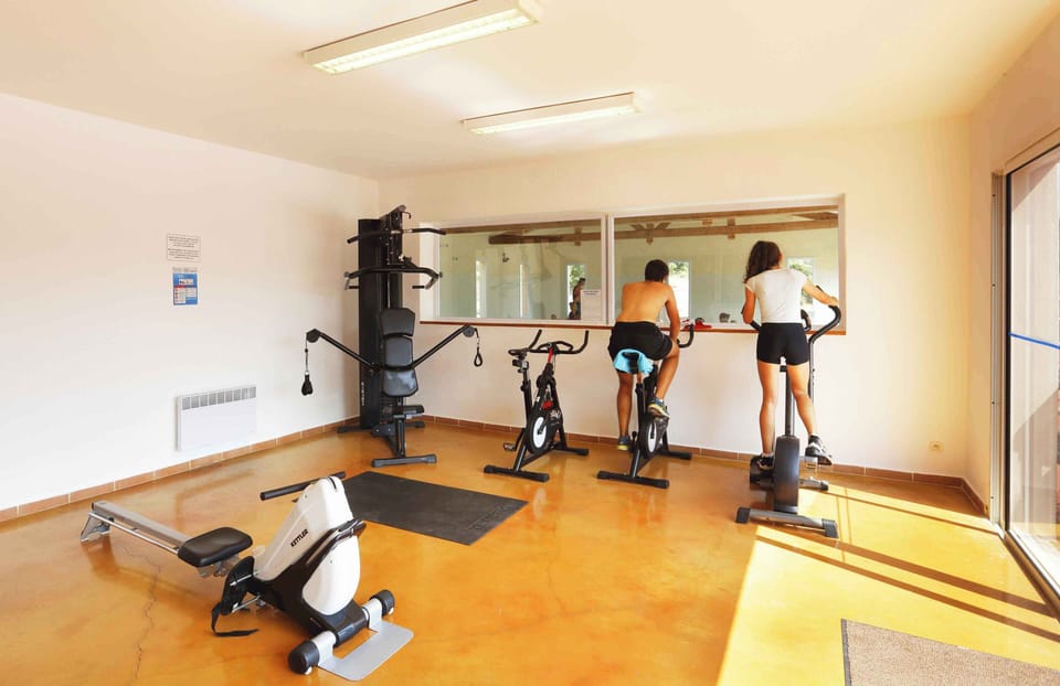 The well-equipped fitness area keeps guests active throughout their stay, with cardio machines and space to train overlooking the estate.