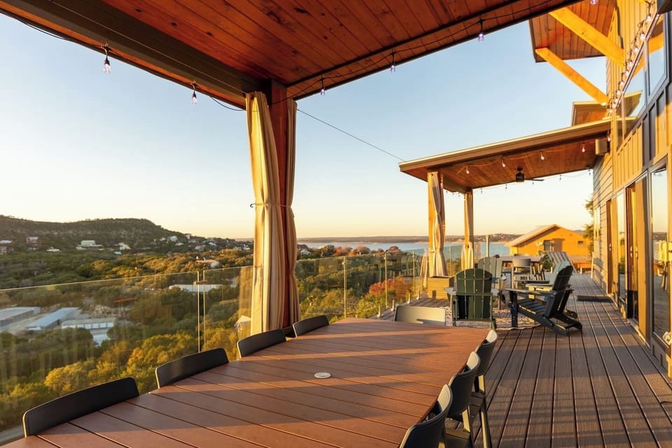 Expansive covered deck with breathtaking lake views and double outdoor dining tables, seating 20+ guests-- perfect for group meals, sunset cocktails, and unforgettable gatherings. 