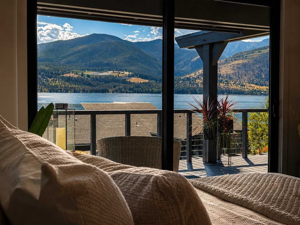 Wake up to breathtaking mountain and lake vistas framed perfectly by expansive floor-to-ceiling bedroom windows.