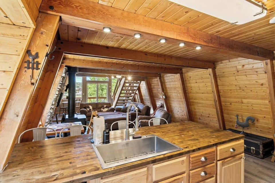 Even the kitchen has character — wood countertops, a farmhouse sink, and that iconic A-frame archway framing your whole stay.