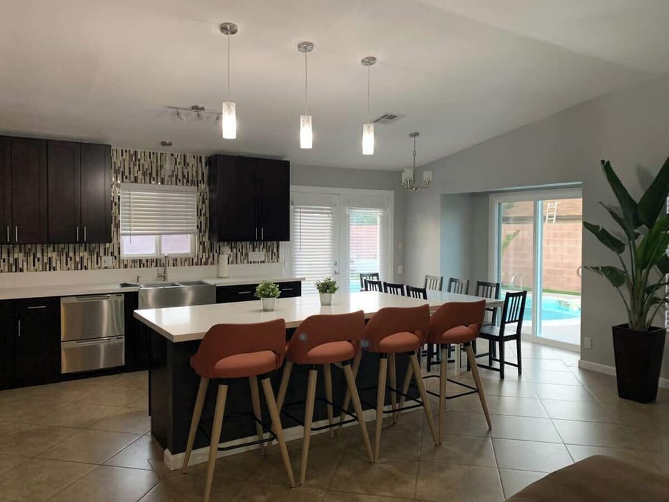 The home offers two distinct dining areas: a bright Breakfast Nook with modern bar-height seating for casual quick meals, and a dedicated Dining Room featuring a large table with seating for up to 8 guests for formal gatherings.