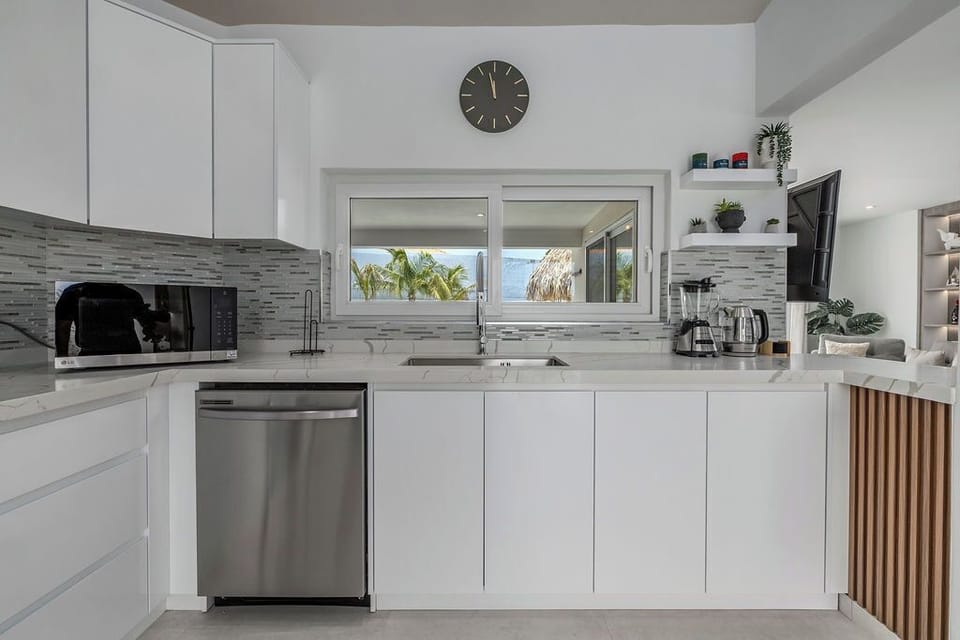 Fully equipped with a spacious stainless-steel French-door refrigerator, a modern range, dishwasher, and microwave.