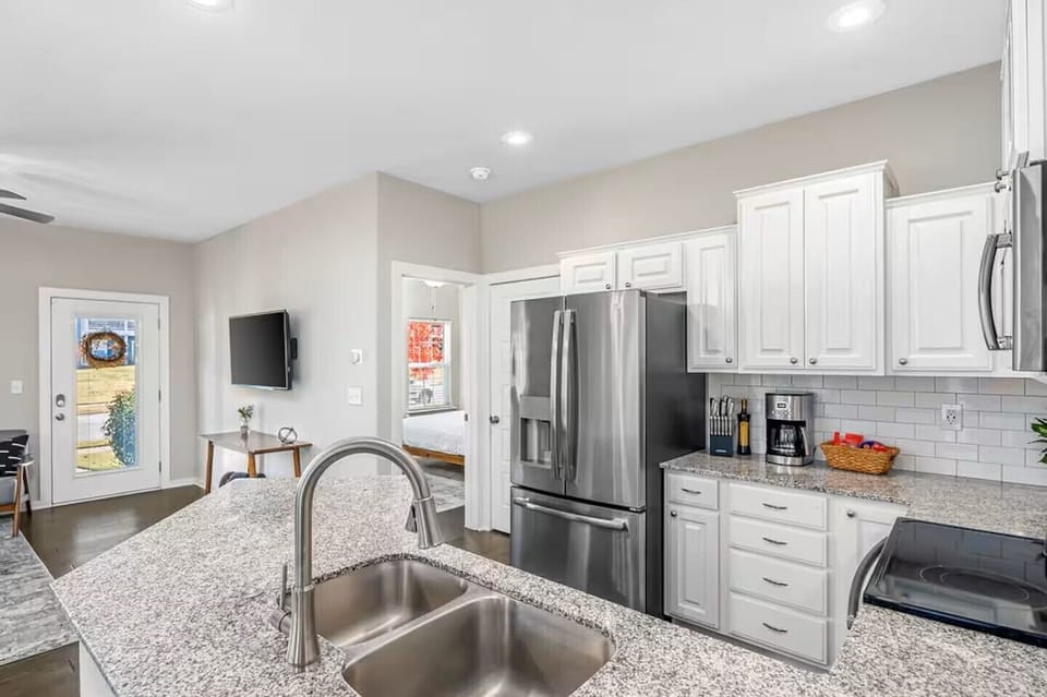 Bright modern kitchen with granite island and stainless appliances