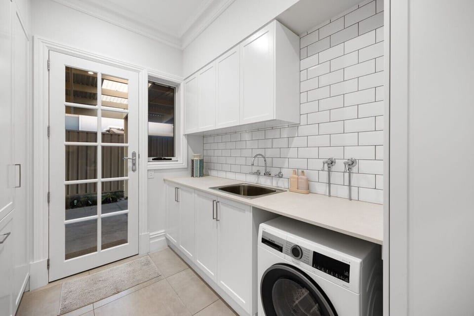 A full-size laundry with a washer, sink, and direct outdoor access with a wash line makes longer stays convenient and easy.