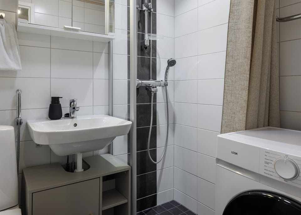 Modern bathroom with walk-in shower and in-unit washer