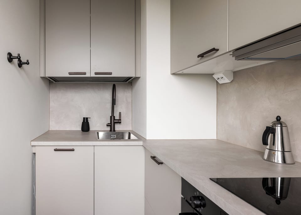 Sleek modern kitchenette with cooktop, sink, and minimalist design