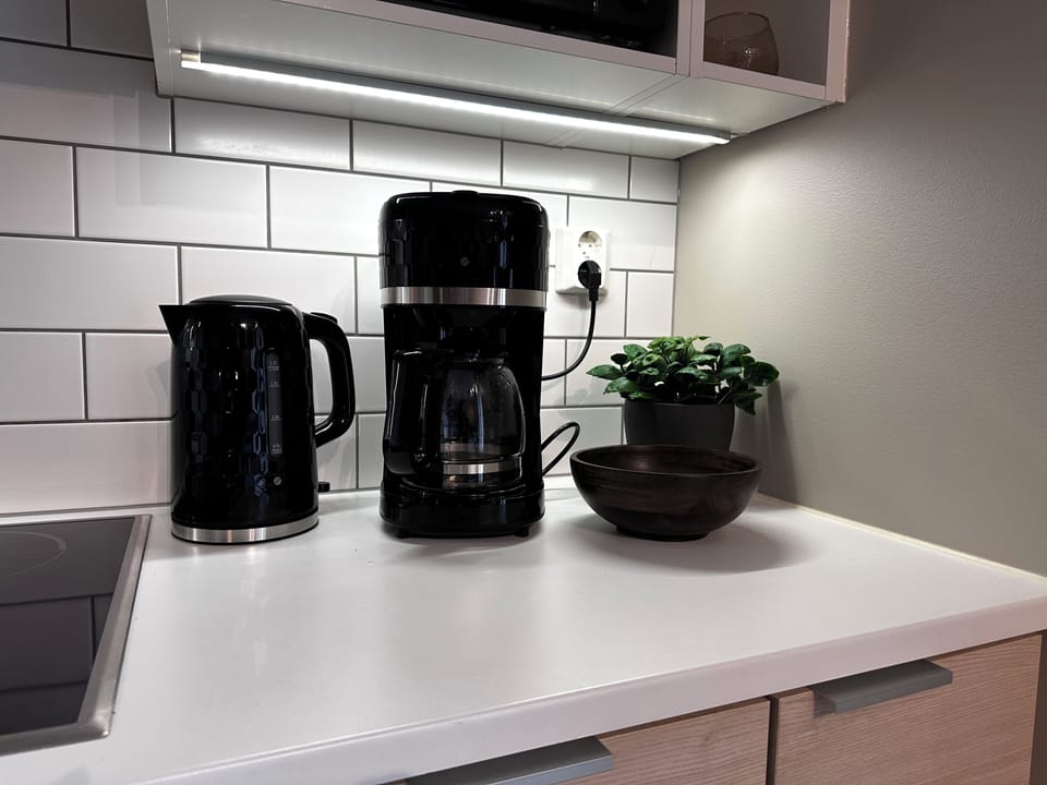 Bright modern kitchen nook with coffee maker, kettle, and sleek finishes