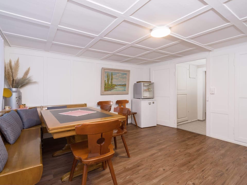 Shared dining area with table, seating, coffee machine, microwave, and coffee provided for guests.
