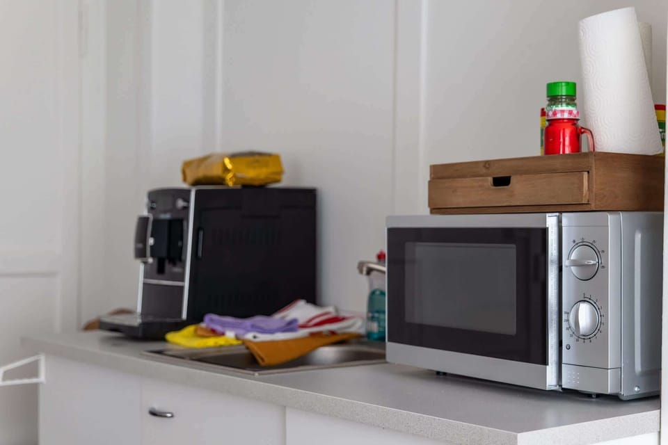Shared dining area with coffee machine, microwave, paper towels, and basic guest essentials.