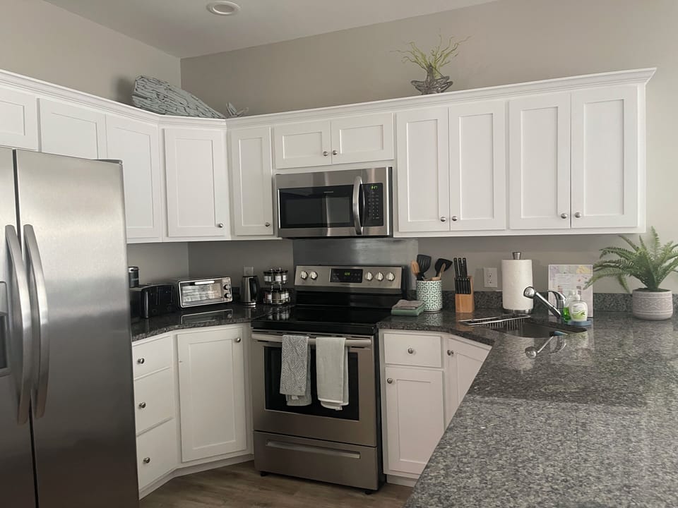 Kitchen stocked w. spices, pots, pans, baking sheet, fridge with filtered water.