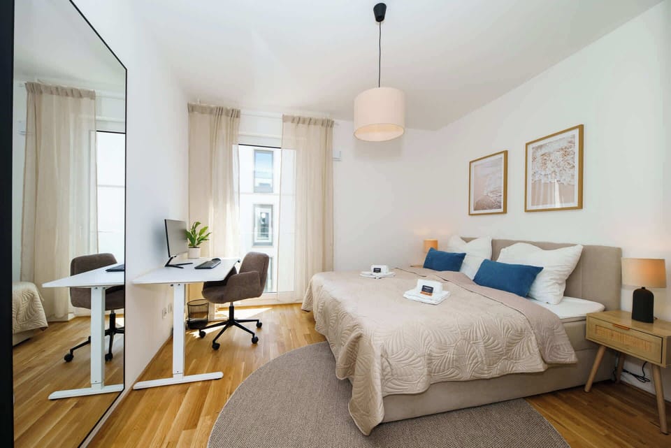 Schlafzimmer mit Kingsize-Bett, Kleiderschrank und höhenverstellbarem Schreibtisch