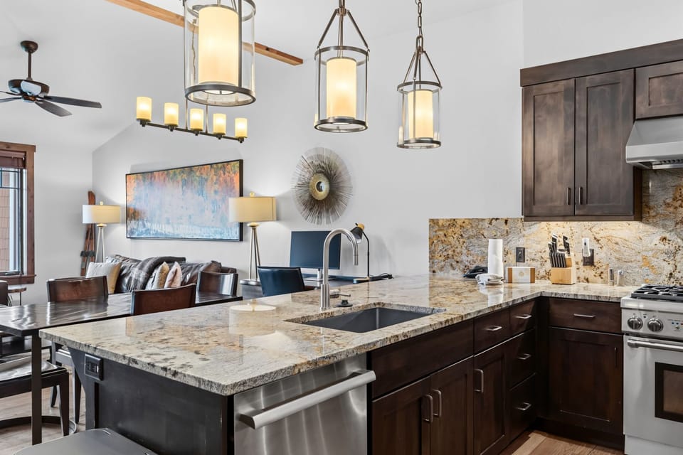 Gather in your fully equipped gourmet kitchen with gleaming granite counters, stainless appliances, and stylish pendant lighting flowing into the living space—perfect for cooking together and creating memories.