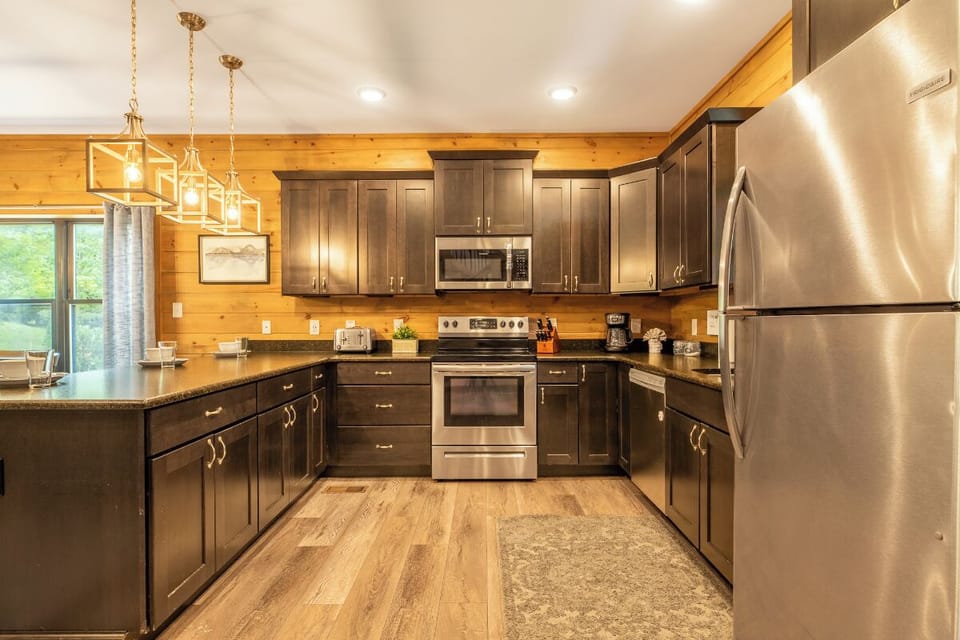 Step into your fully equipped kitchen with rich wood finishes, granite countertops, and modern stainless steel appliances—everything you need to whip up delicious meals during your mountain getaway.