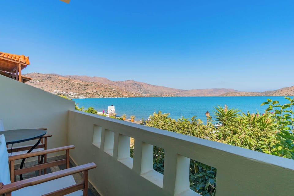 Balcony view overlooking the sea and green surroundings.