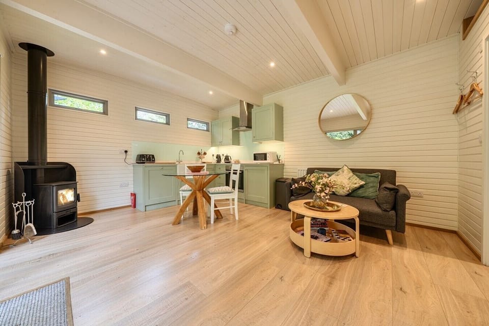 Open-plan living with a cosy wood burner and forest views right outside
