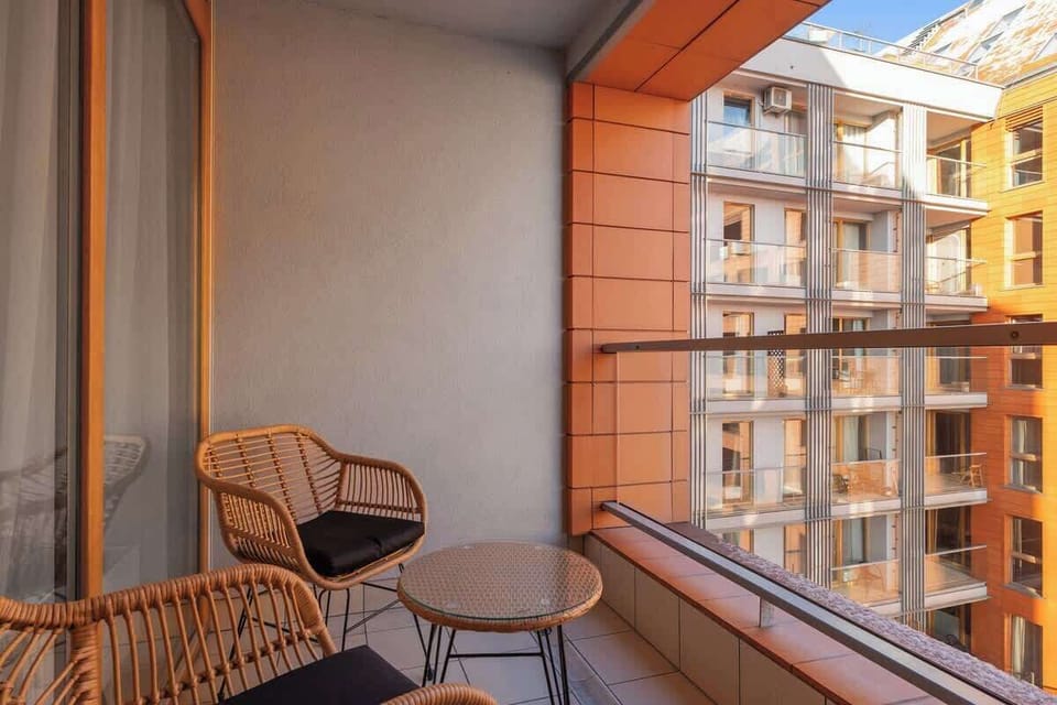 Z salonu można wyjść bezpośrednio na balkon z widokiem na rzekę, na którym przygotowano komplet mebli – doskonały na poranną kawę lub wieczorny odpoczynek.