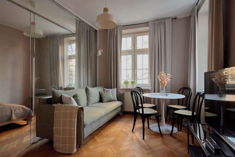 Jasny salon stanowi serce apartamentu. Wyposażony został w wygodną, rozkładaną sofę z funkcją spania, która zapewnia dodatkowe miejsce noclegowe, oraz telewizor.