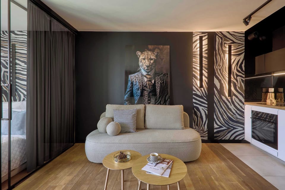 Salon urządzony w nowoczesnym stylu stanowi serce apartamentu. Znajduje się tu wygodna, rozkładana sofa, idealna zarówno do wypoczynku, jak i nocnego relaksu. Naprzeciwko ustawiono telewizor z kanałami TV oraz funkcją Smart TV.