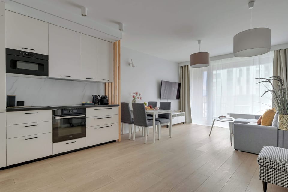 Chlebova 2.06 to jasny i funkcjonalny apartament dla 5 osób, w tym maksymalnie 4 dorosłych. Oferuje sypialnię, salon z aneksem kuchennym i jadalnią, łazienkę z prysznicem i pralką oraz balkon z widokiem na rzekę.