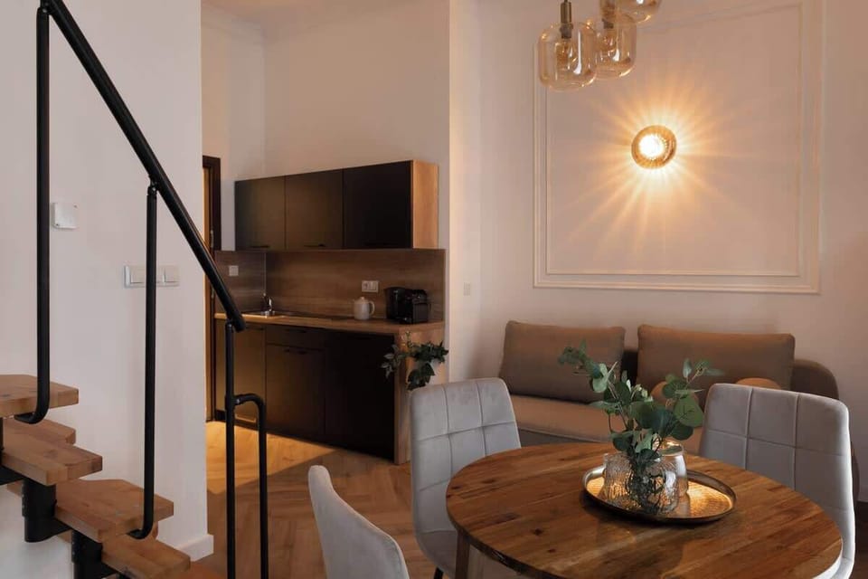 W apartamencie znajduje się również funkcjonalny aneks kuchenny, wyposażony w płytę kuchenną, czajnik elektryczny oraz ekspres do kawy, umożliwiający przygotowanie prostych posiłków i porannej kawy.