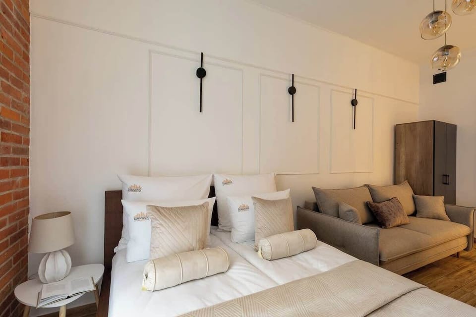 Główną część apartamentu stanowi stylowe studio z łóżkiem małżeńskim, telewizorem z dostępem do telewizji naziemnej i Smart TV, rozkładaną sofą oraz pojemną szafą do przechowywania ubrań i bagażu.