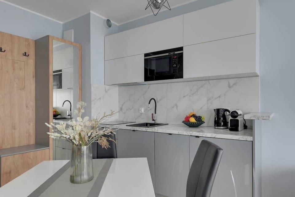 Aneks kuchenny został w pełni wyposażony i utrzymany w nowoczesnej, eleganckiej stylistyce. Do dyspozycji gości jest płyta grzewcza, mikrofalówka, lodówka, ekspres do kawy, czajnik oraz niezbędne naczynia i akcesoria kuchenne.
