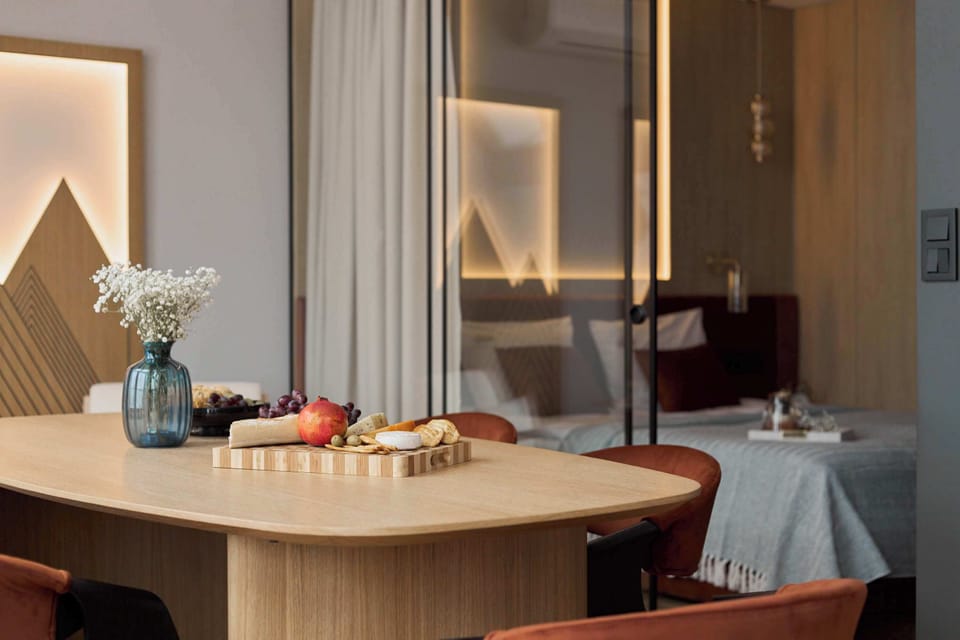 Na pierwszym poziomie znajduje się przytulny salon z rozkładaną sofą i dużym stołem jadalnianym. W przedpokoju umieszczono praktyczną szafę z ukrytą pralką, która zwiększa wygodę podczas pobytu.
