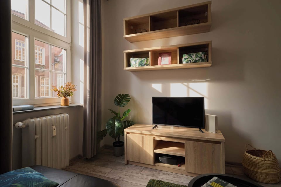 Apartament składa się z jasnego salonu z wygodną sofą, stolikiem kawowym, telewizorem oraz częścią jadalnianą. 