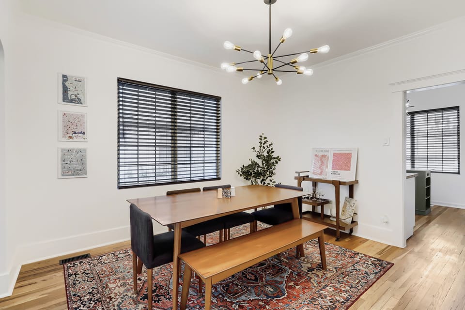Gather around your stylish dining table beneath warm midcentury lighting, perfect for sharing meals and making memories with your travel companions.