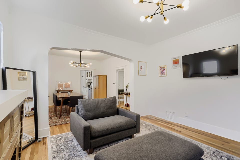Unwind in your stylish living space with modern furnishings, warm wood floors, and an open flow into the dining area—perfect for relaxing after a day of exploring.