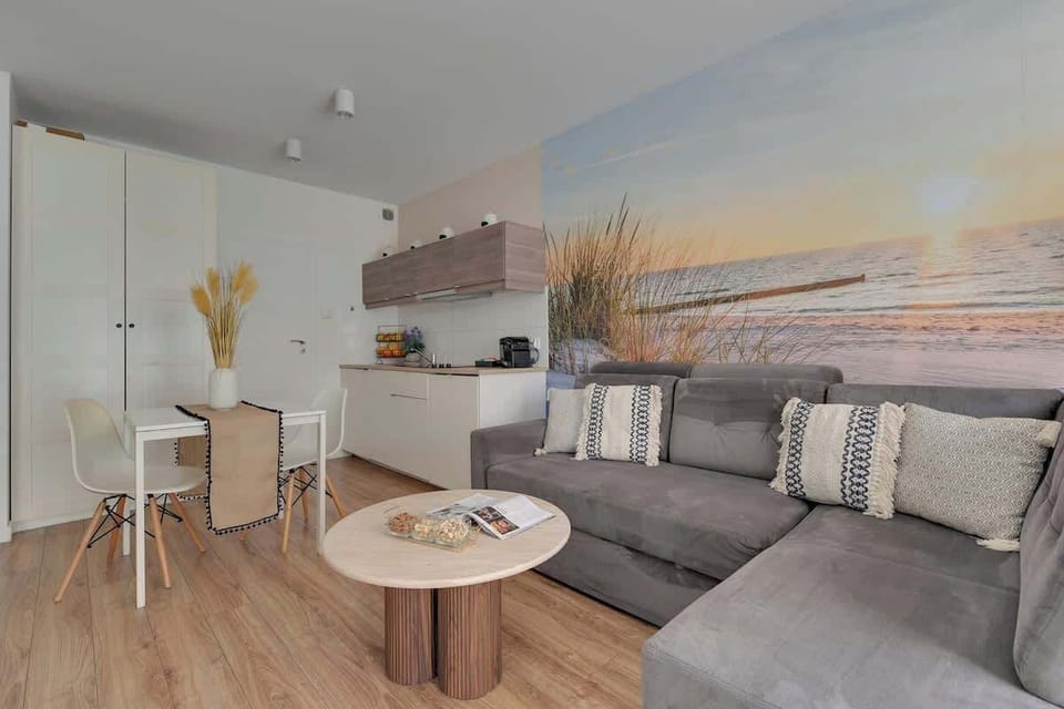 Salon stanowi serce apartamentu i oferuje wygodną, rozkładaną sofę, która może pełnić funkcję dodatkowego miejsca do spania. Naprzeciwko znajduje się telewizor z dostępem do kanałów kablowych.