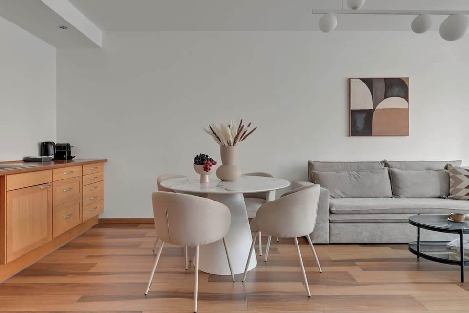 Największym atutem salonu są panoramiczne okna z widokiem na rzekę Motławę i zabytkową zabudowę Starego Miasta. Wygodna, rozkładana sofa z funkcją spania, duży telewizor i elegancki stół jadalniany sprzyjają wspólnemu spędzaniu czasu.